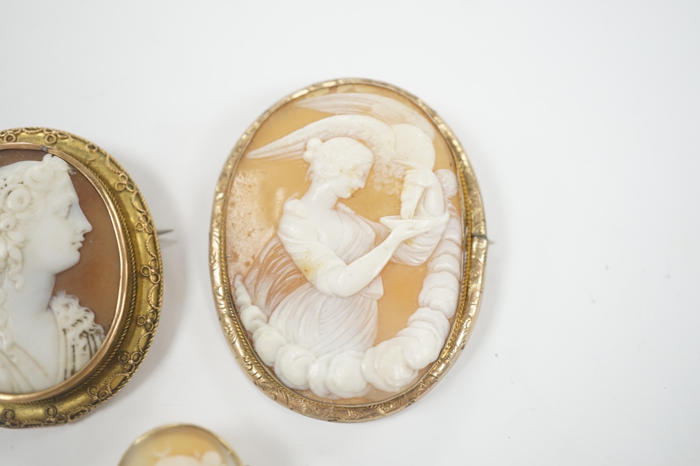 Two yellow metal mounted oval cameo shell brooches, the largest depicting Diana and the Eagle, 55mm and one other gilt metal mounted oval cameo shell brooch.